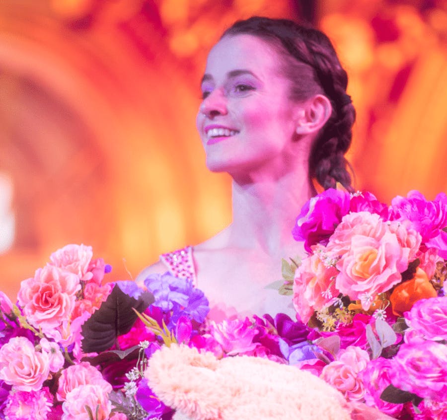 Lady in a custome full of flowers while performing onboard